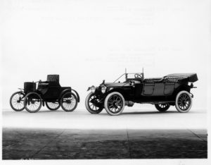 1913 Packard 48 three-quarter front view, left side, top folded, two-toned, pictured with 1899 Packard Model A in background, three-quarter front view, left side. Inscribed on photo back: "Left 1899 1-cylinder, 9-horsepower, 71.5-inch wheelbase, 2-person roadster, right 1913, 6-cylinder, 48-horsepower ALAM rating, 82-horsepower at 1720 r.p.m., 139-inch wheelbase, 5-person phaeton."