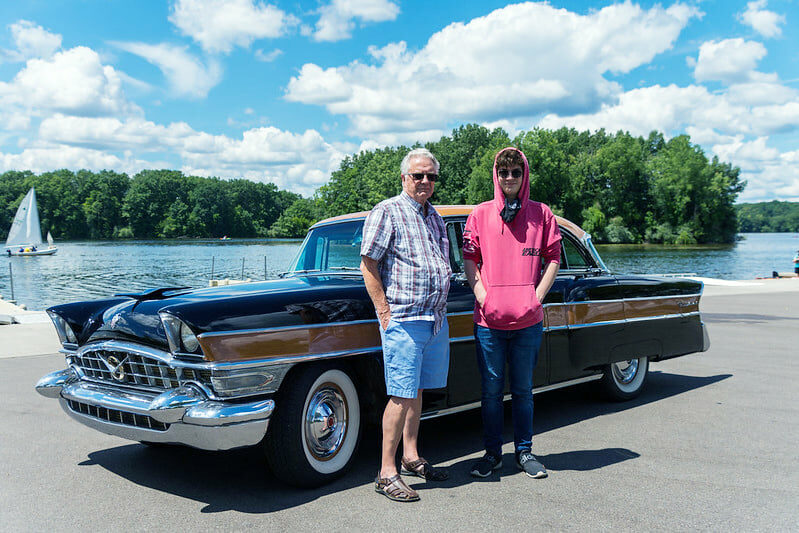 2 men in front of a 1956 Packard Executive Sedan