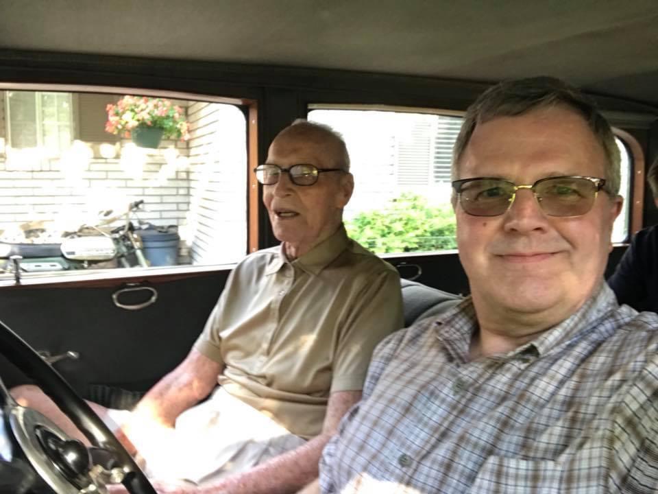 Two men in the front seats of a 1929 Packard