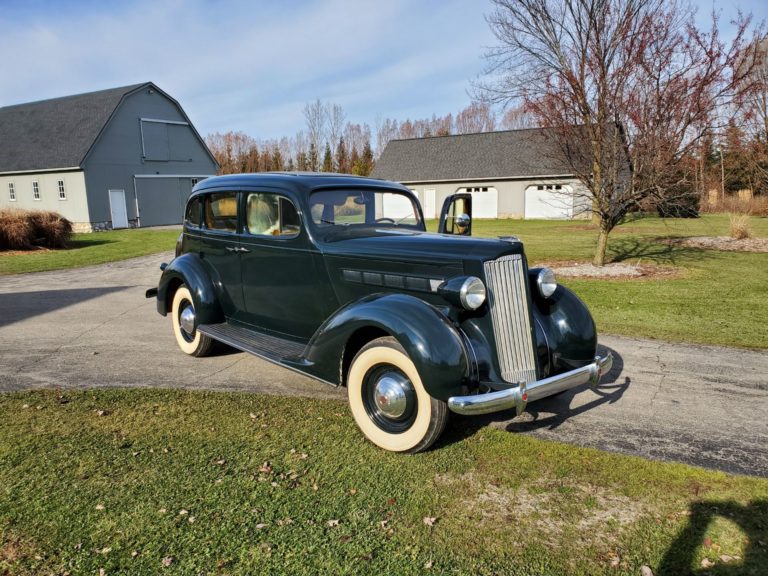 1937 Packard on a driveway with a pole barn and extra garage in the background