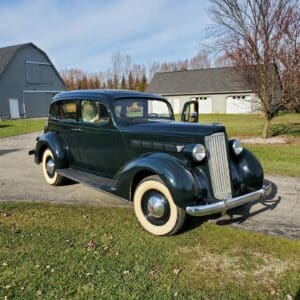 1937 Packard on a driveway with a pole barn and extra garage in the background